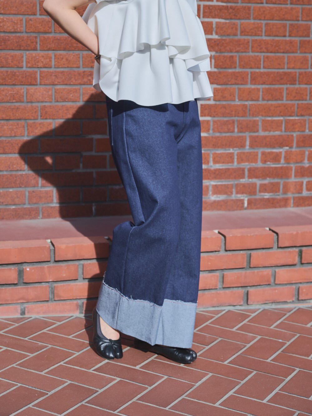 ブルー系のデニムパンツを着用したレディースの春コーディネートの3枚目の写真