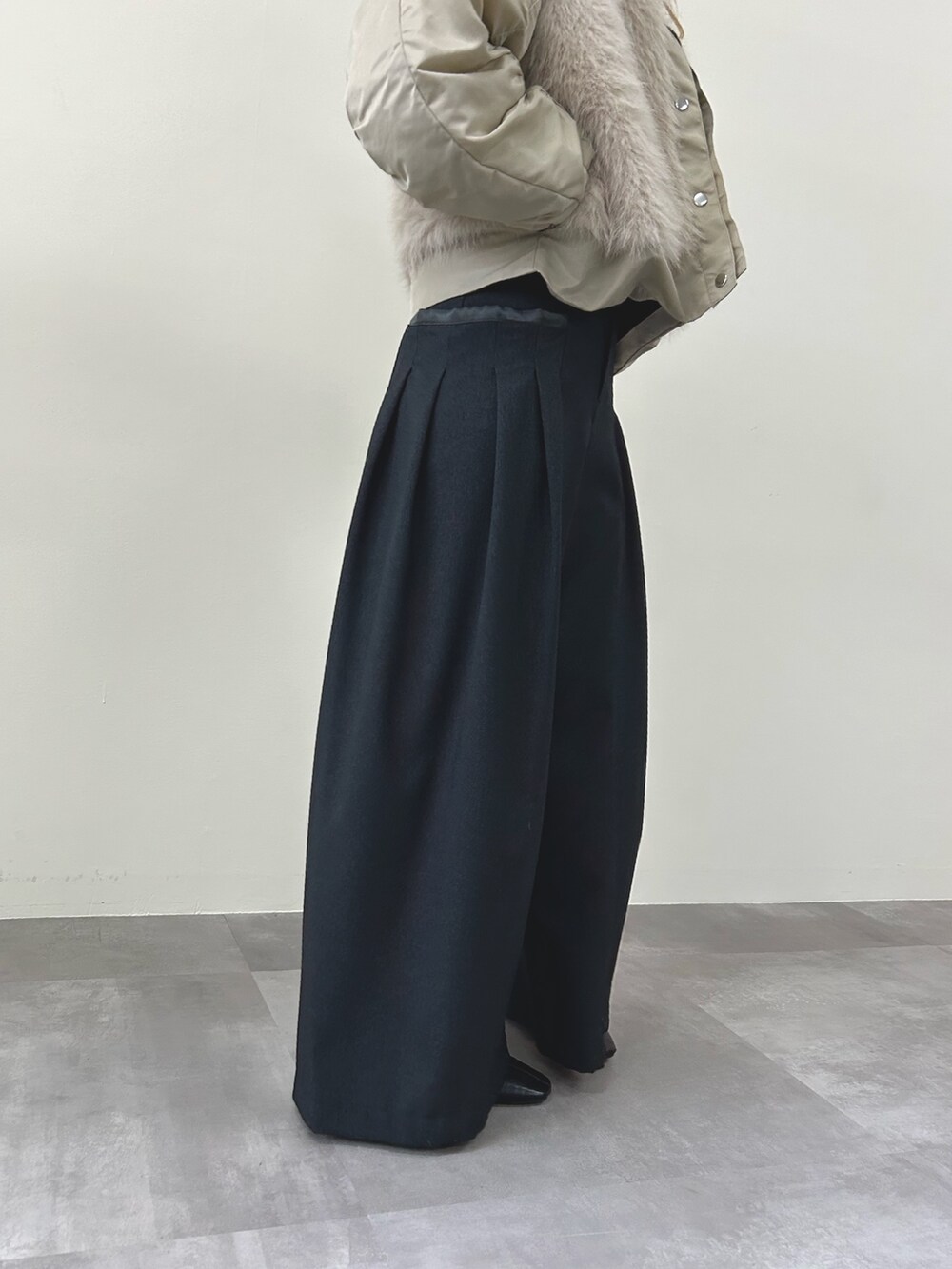 ベージュ系のダウンジャケット/コート、グレー系のスラックスを着用したレディースの秋コーディネートの3枚目の写真