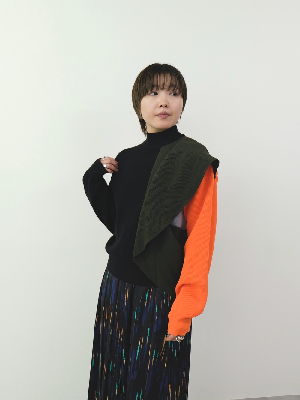 ブラック系のニット/セーター、ブラック系のスカートを着用したレディースの秋コーディネートの2枚目の写真