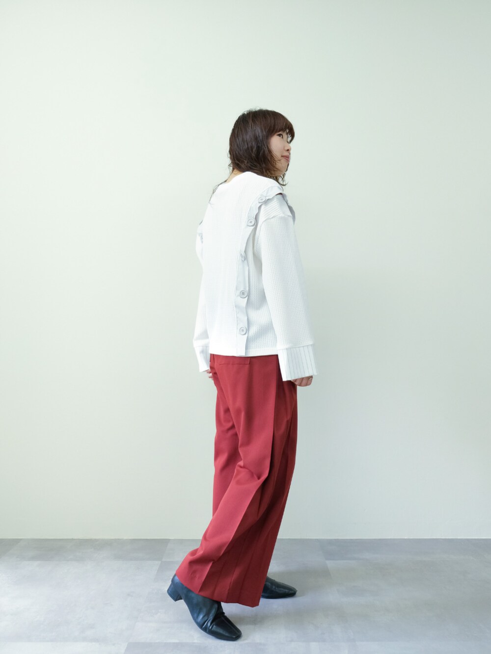 ホワイト系のTシャツ/カットソー、レッド系のスラックスを着用したレディースの秋コーディネートの2枚目の写真