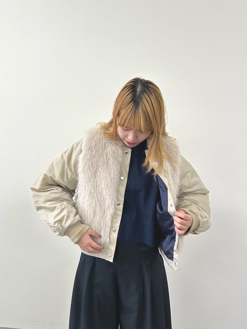 ベージュ系のダウンジャケット/コート、グレー系のスラックスを着用したレディースの秋コーディネートの2枚目の写真