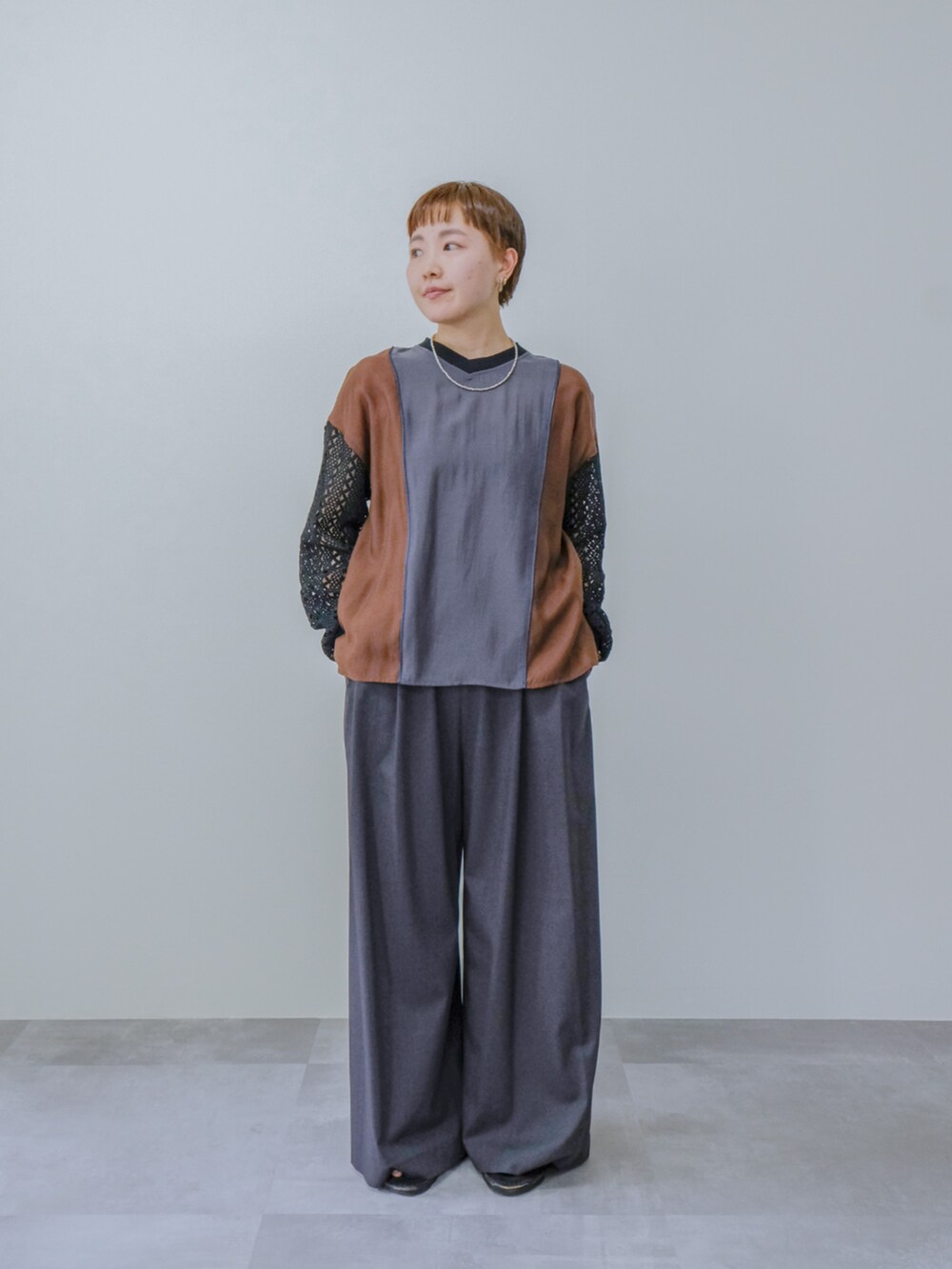 グレー系のシャツ/ブラウス、グレー系のスラックスを着用したレディースの秋コーディネートの2枚目の写真