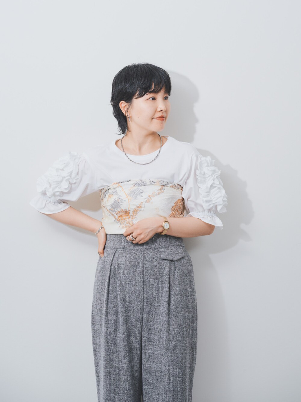 ホワイト系のTシャツ/カットソー、グレー系のスラックスを着用したレディースの夏コーディネートの2枚目の写真