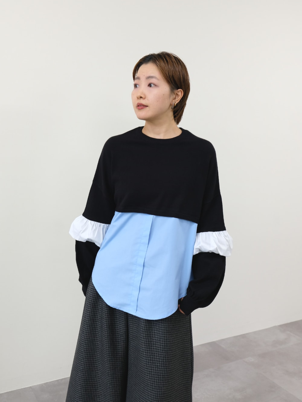 ブラック系のニット/セーター、グレー系のスラックスを着用したレディースの秋コーディネートの3枚目の写真