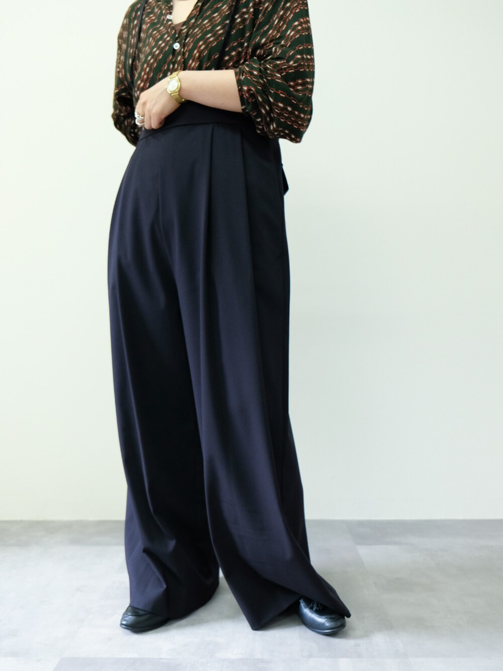 ブラック系のスラックスを着用したレディースの秋コーディネートの3枚目の写真