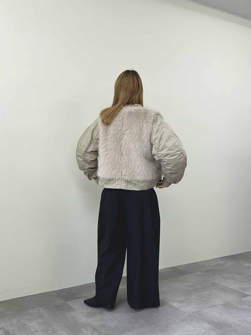 ベージュ系のダウンジャケット/コート、グレー系のスラックスを着用したレディースの秋コーディネートの5枚目の写真