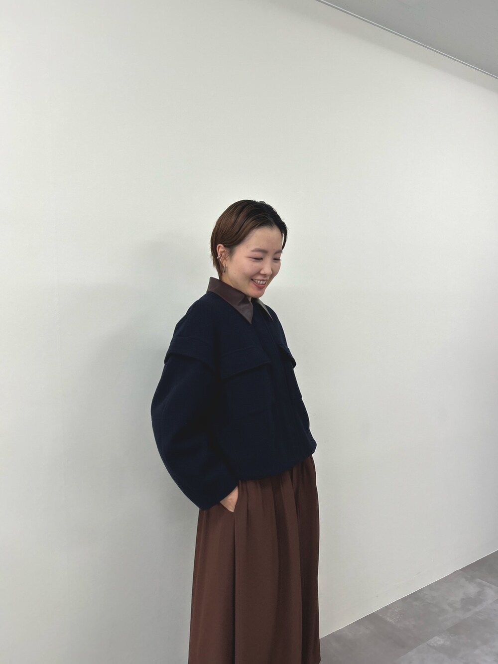 ブルー系のミリタリージャケット、ブラウン系のワンピースを着用したレディースの秋コーディネートの3枚目の写真