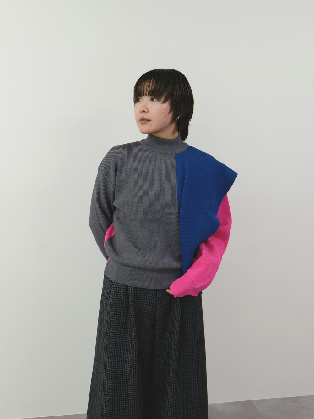 グレー系のニット/セーター、グレー系のスラックスを着用したレディースの秋コーディネートの2枚目の写真