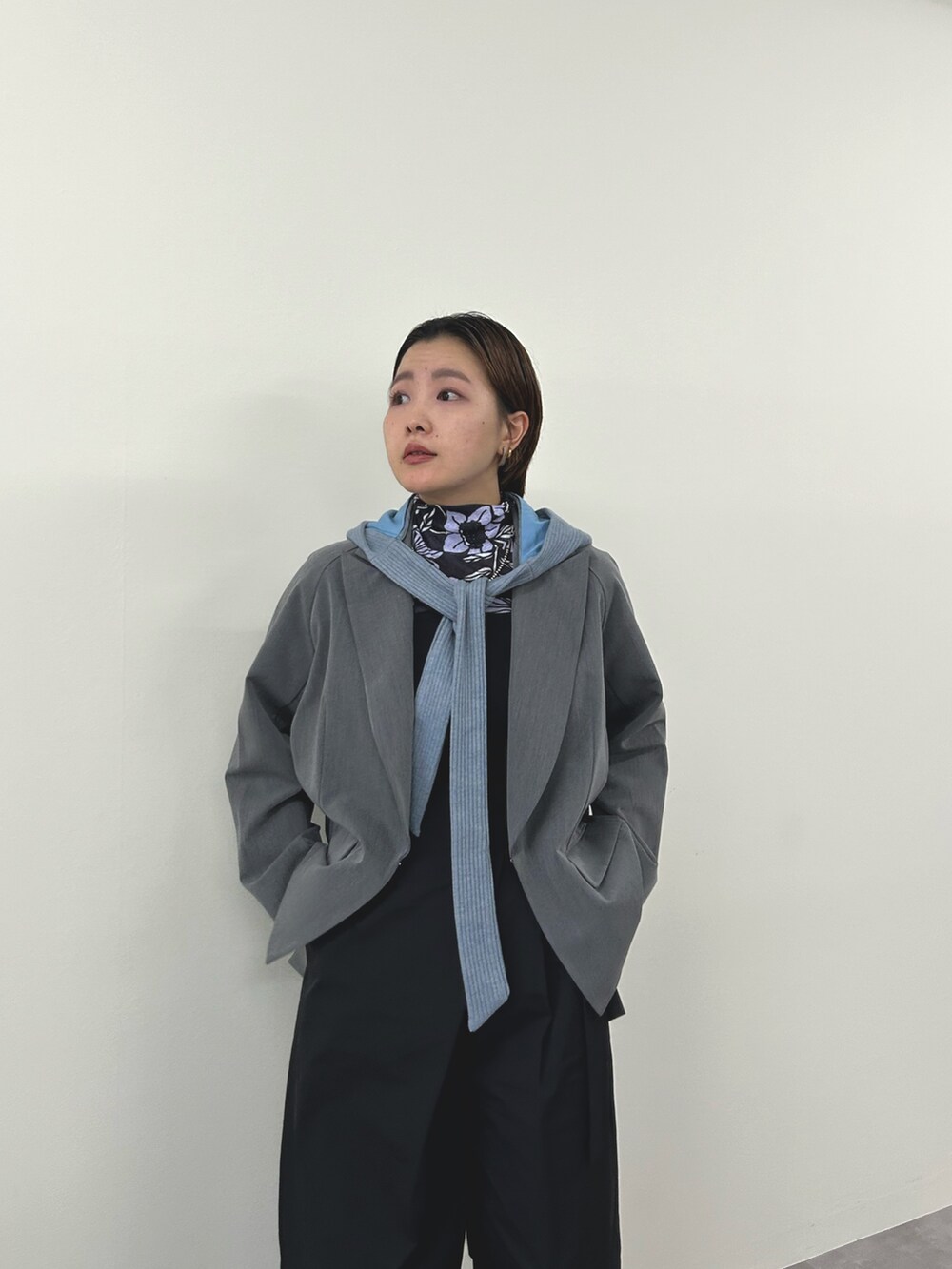 グレー系のテーラードジャケット、ブラック系のチノパンツを着用したレディースの秋コーディネートの3枚目の写真