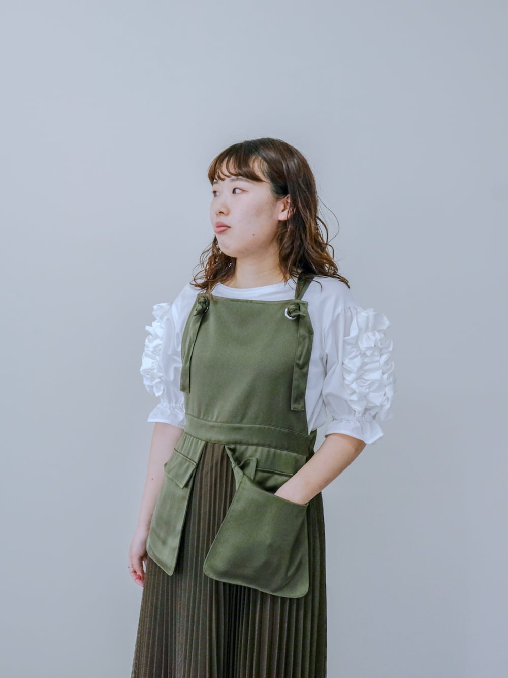 ホワイト系のTシャツ/カットソー、グリーン系のワンピースを着用したレディースの秋コーディネートの2枚目の写真