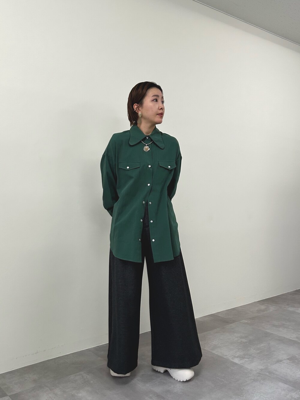 グリーン系のシャツ/ブラウス、グレー系のスラックスを着用したレディースの秋コーディネートの3枚目の写真