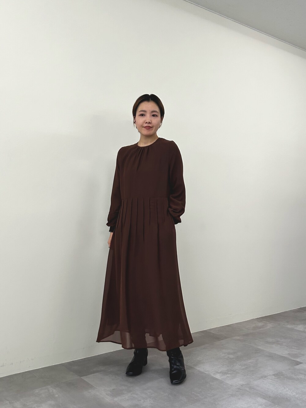 ブルー系のミリタリージャケット、ブラウン系のワンピースを着用したレディースの秋コーディネートの5枚目の写真