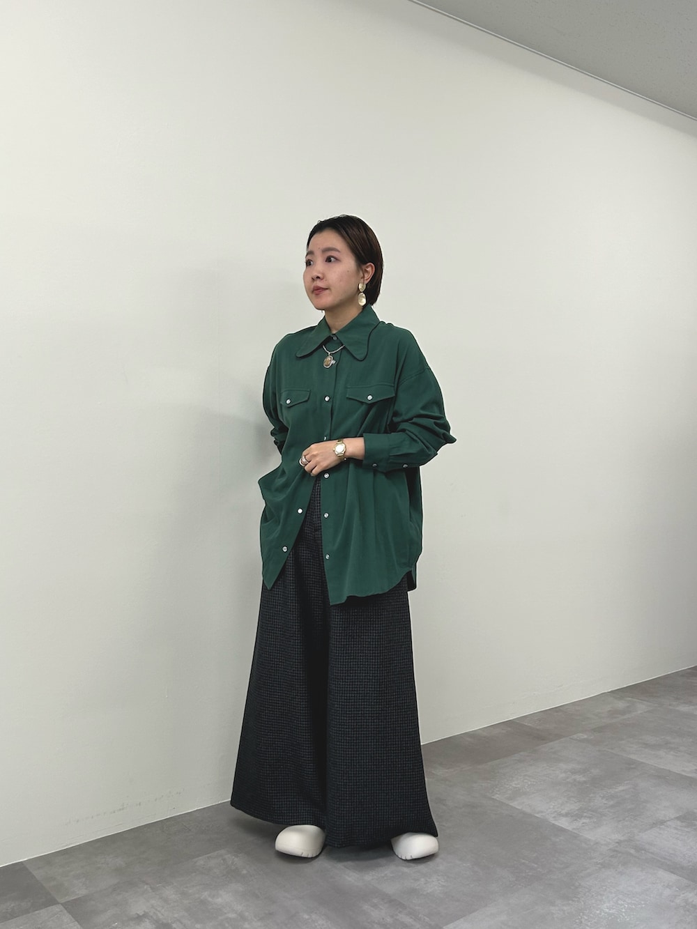 グリーン系のシャツ/ブラウス、グレー系のスラックスを着用したレディースの秋コーディネートの2枚目の写真