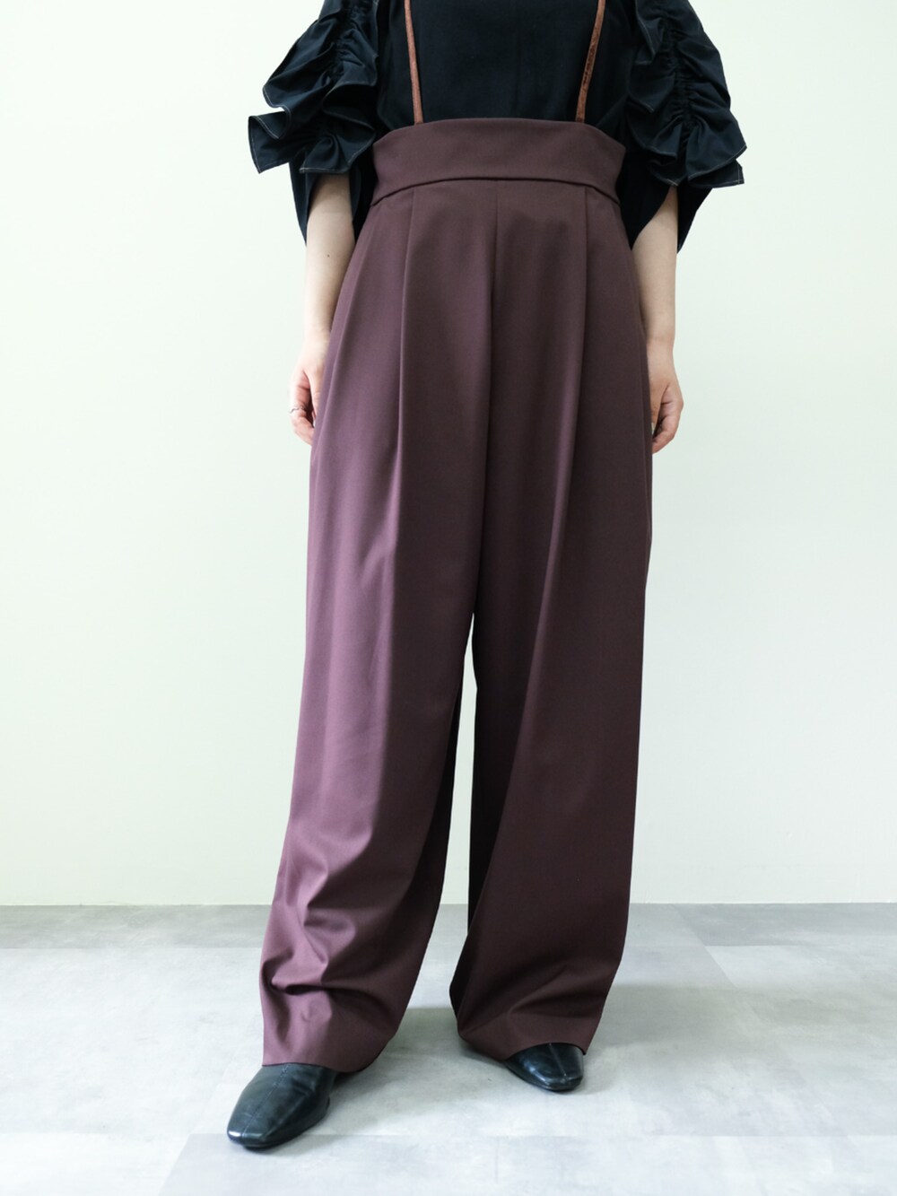 ブラック系のTシャツ/カットソー、ブラウン系のスラックスを着用したレディースの秋コーディネートの3枚目の写真