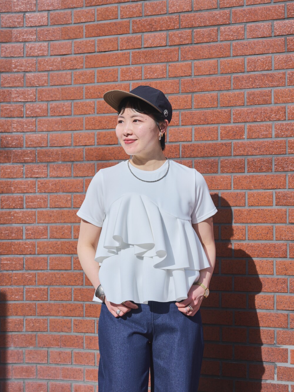 ブルー系のデニムパンツを着用したレディースの春コーディネートの2枚目の写真