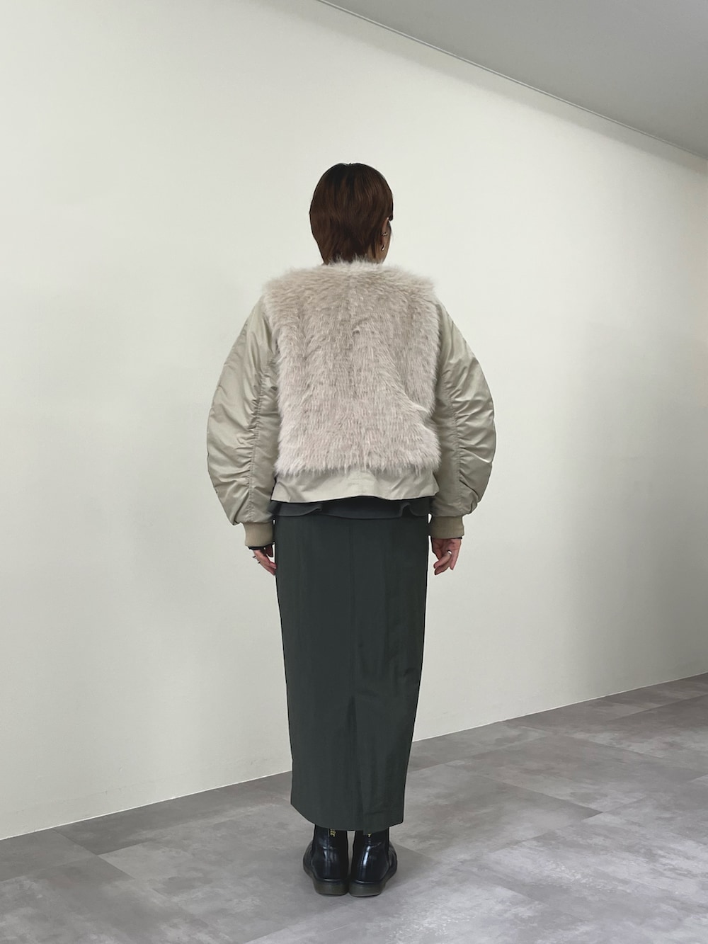 ベージュ系のダウンジャケット/コート、グリーン系のワンピースを着用したレディースの秋コーディネートの3枚目の写真