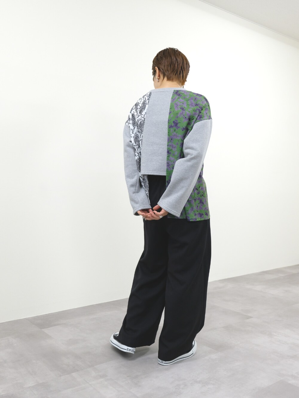 グレー系のスウェット、ブラック系のスラックスを着用したレディースの秋コーディネートの2枚目の写真