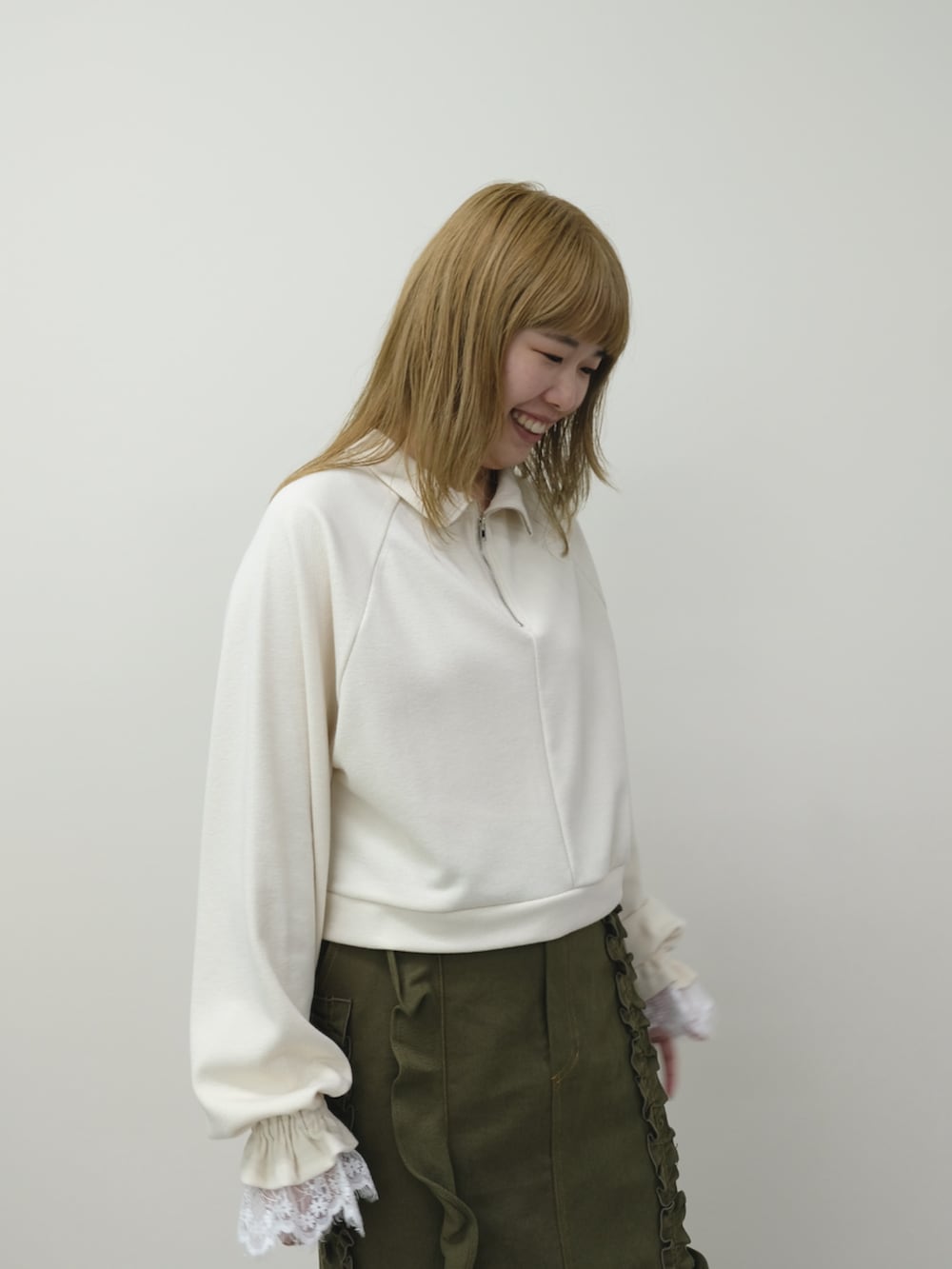 ホワイト系のジャージ、グリーン系のスカートを着用したレディースの秋コーディネートの3枚目の写真