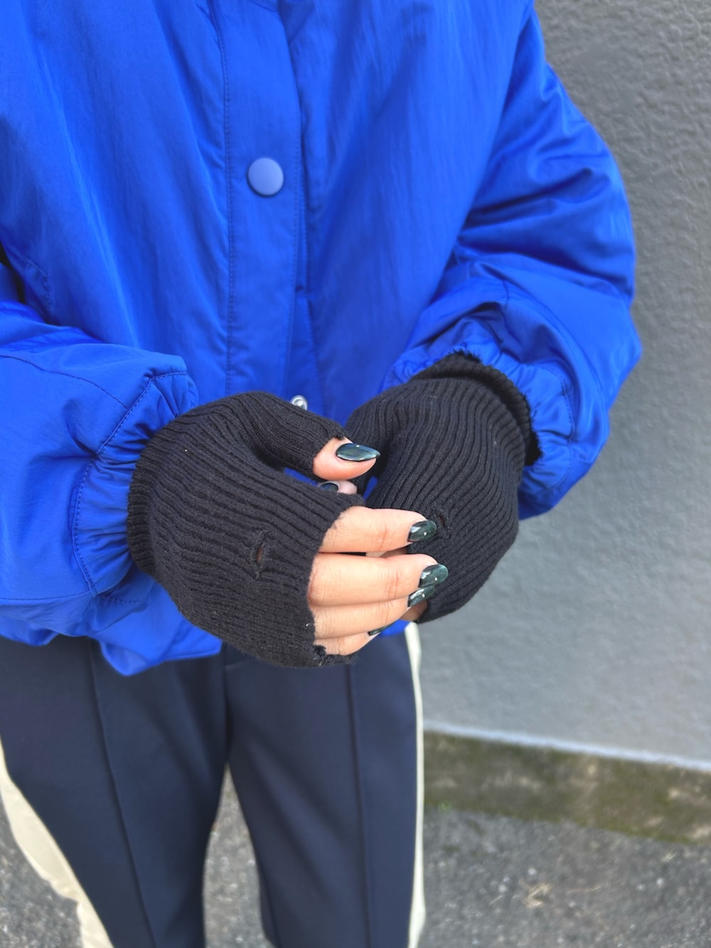 ブルー系のナイロンジャケット、ブラック系のニット/セーター、ブルー系のその他パンツを着用したレディースの秋コーディネートの4枚目の写真
