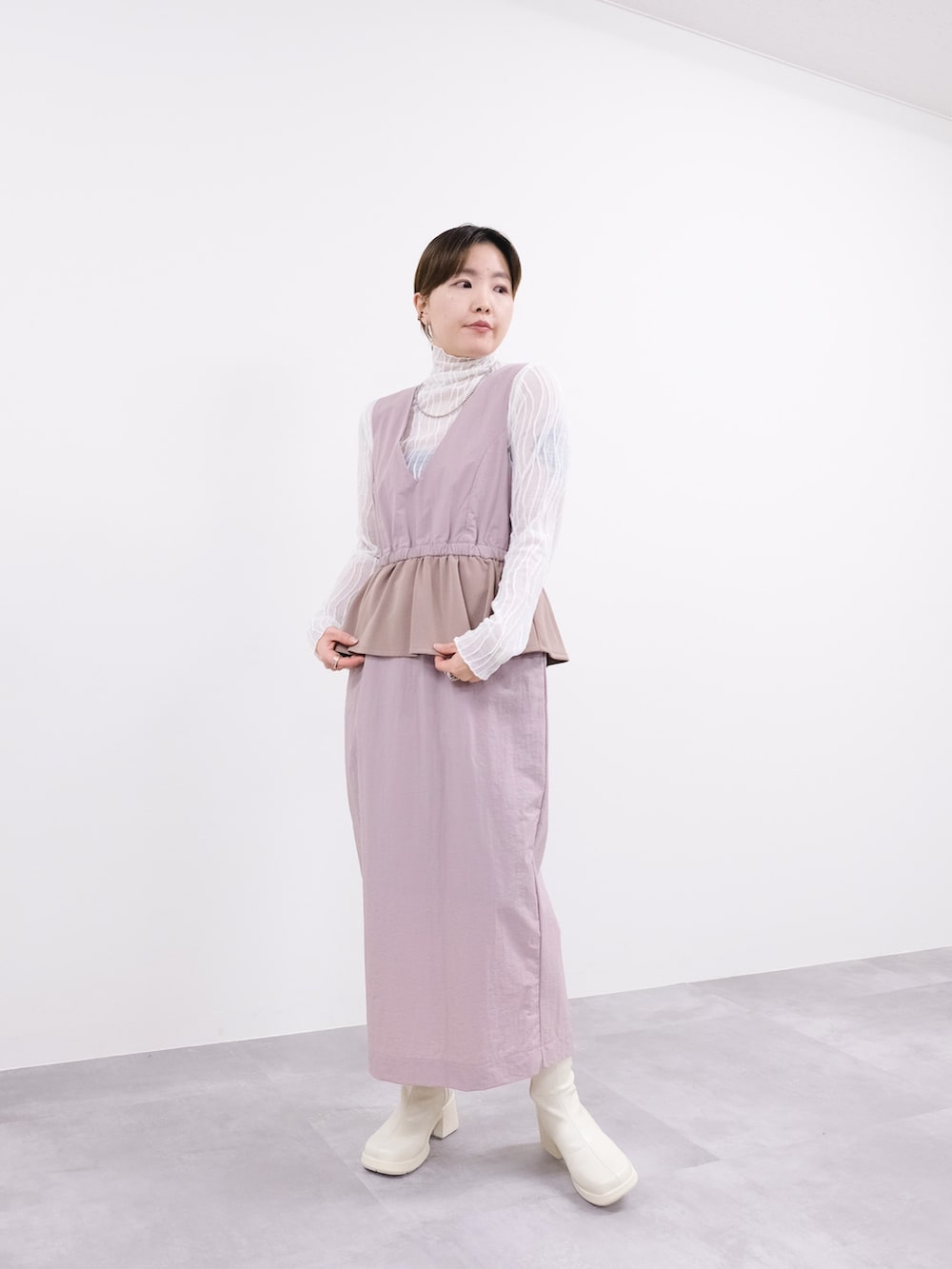 ピンク系のナイロンジャケット、ピンク系のワンピース、ホワイト系のTシャツ/カットソーを着用したレディースの冬コーディネートの2枚目の写真