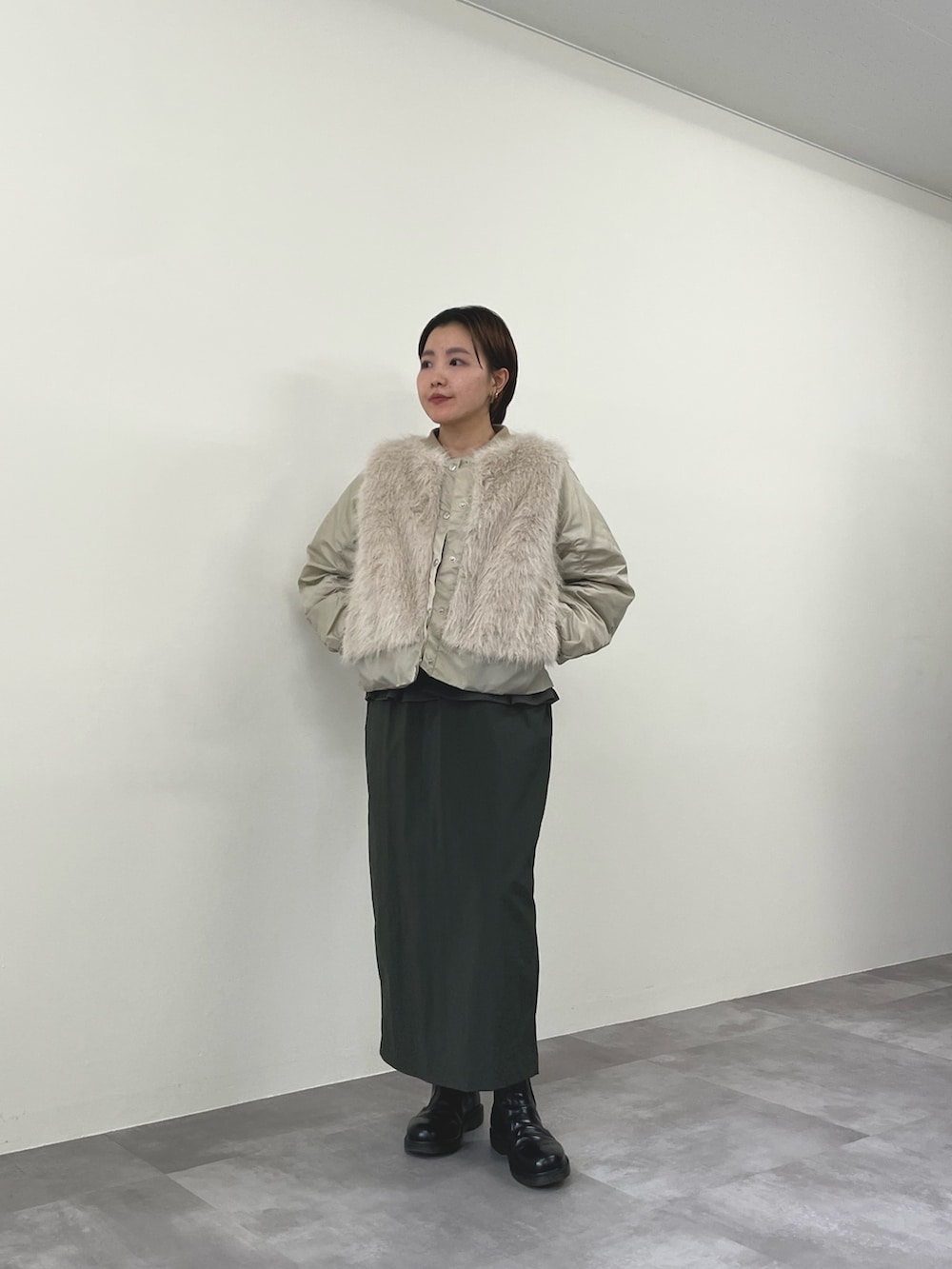 ベージュ系のダウンジャケット/コート、グリーン系のワンピースを着用したレディースの秋コーディネートの2枚目の写真