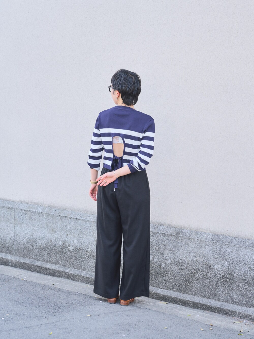 ブラック系のスラックスを着用したレディースの春コーディネートの2枚目の写真