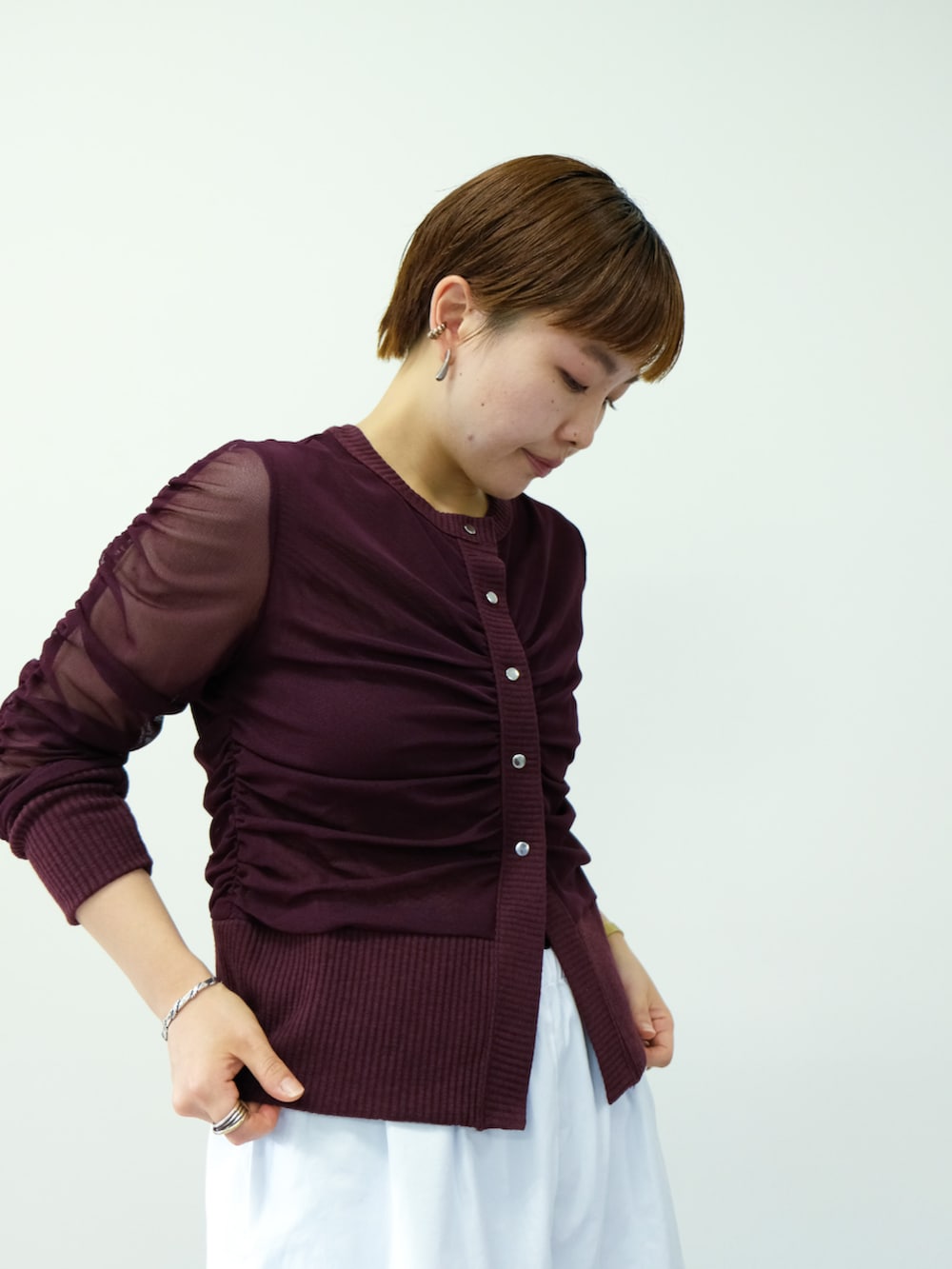 レッド系のカーディガン/ボレロを着用したレディースの秋コーディネートの2枚目の写真