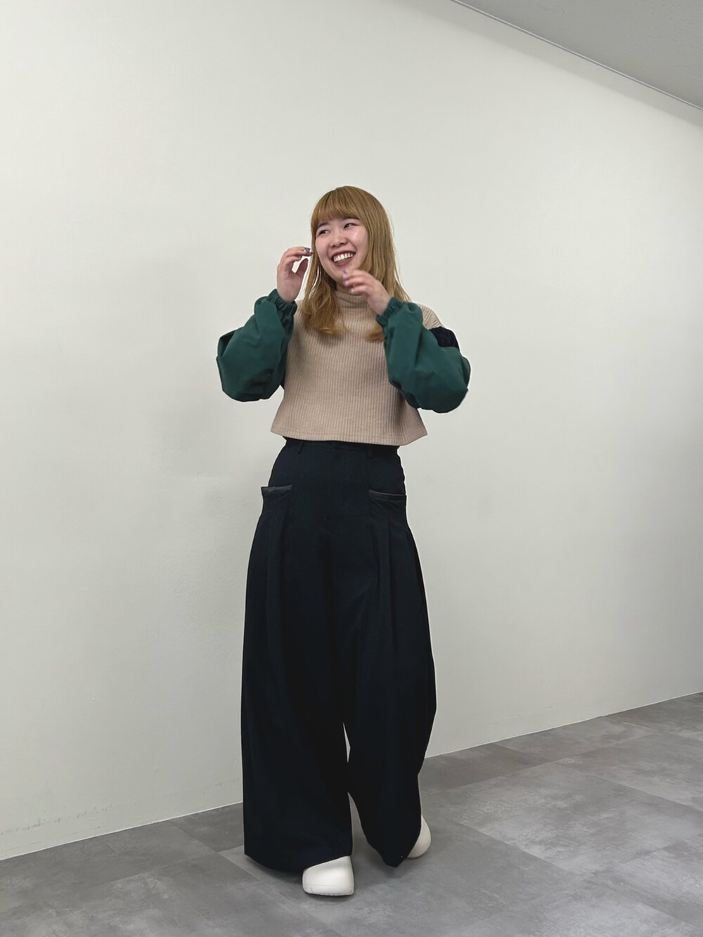 ベージュ系のニット/セーター、グレー系のスラックスを着用したレディースの秋コーディネートの4枚目の写真