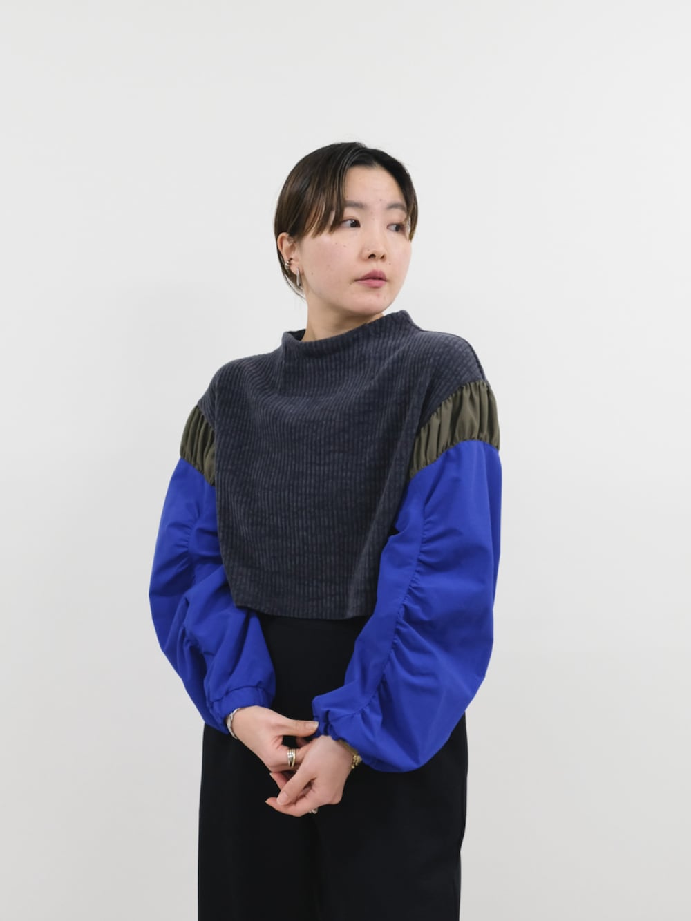 グレー系のニット/セーター、ブラック系のその他パンツ、ブラック系のダウンジャケット/コートを着用したレディースの冬コーディネートの3枚目の写真