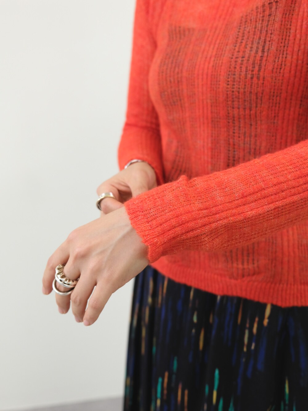 オレンジ系のニット/セーター、ブラック系のスカートを着用したレディースの秋コーディネートの4枚目の写真