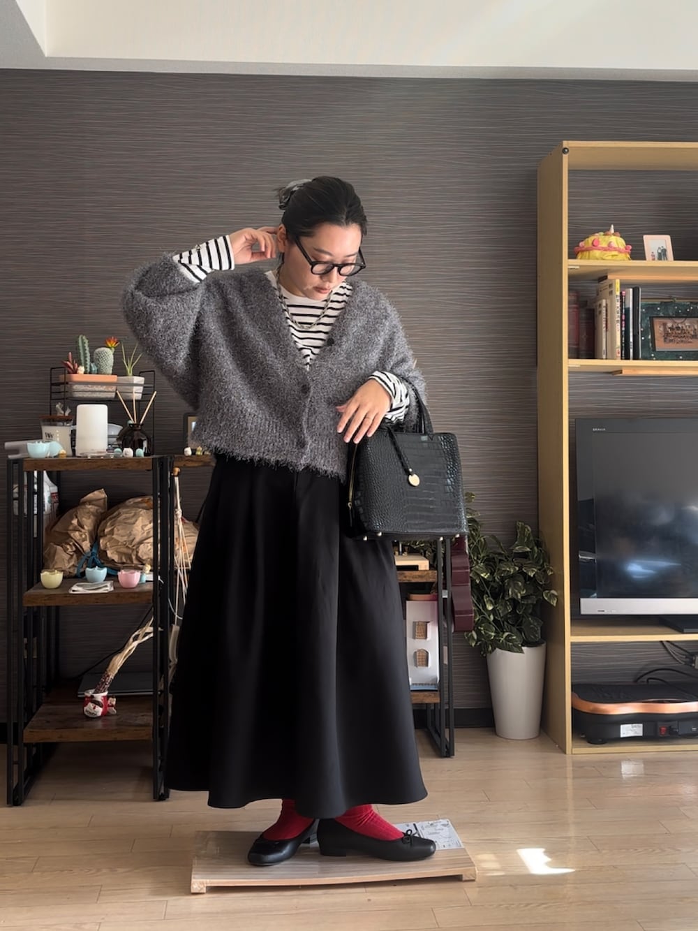 ブラック系のバレエシューズ、ブラック系のスカート、ブラック系のバッグを着用したレディースの冬コーディネートの2枚目の写真