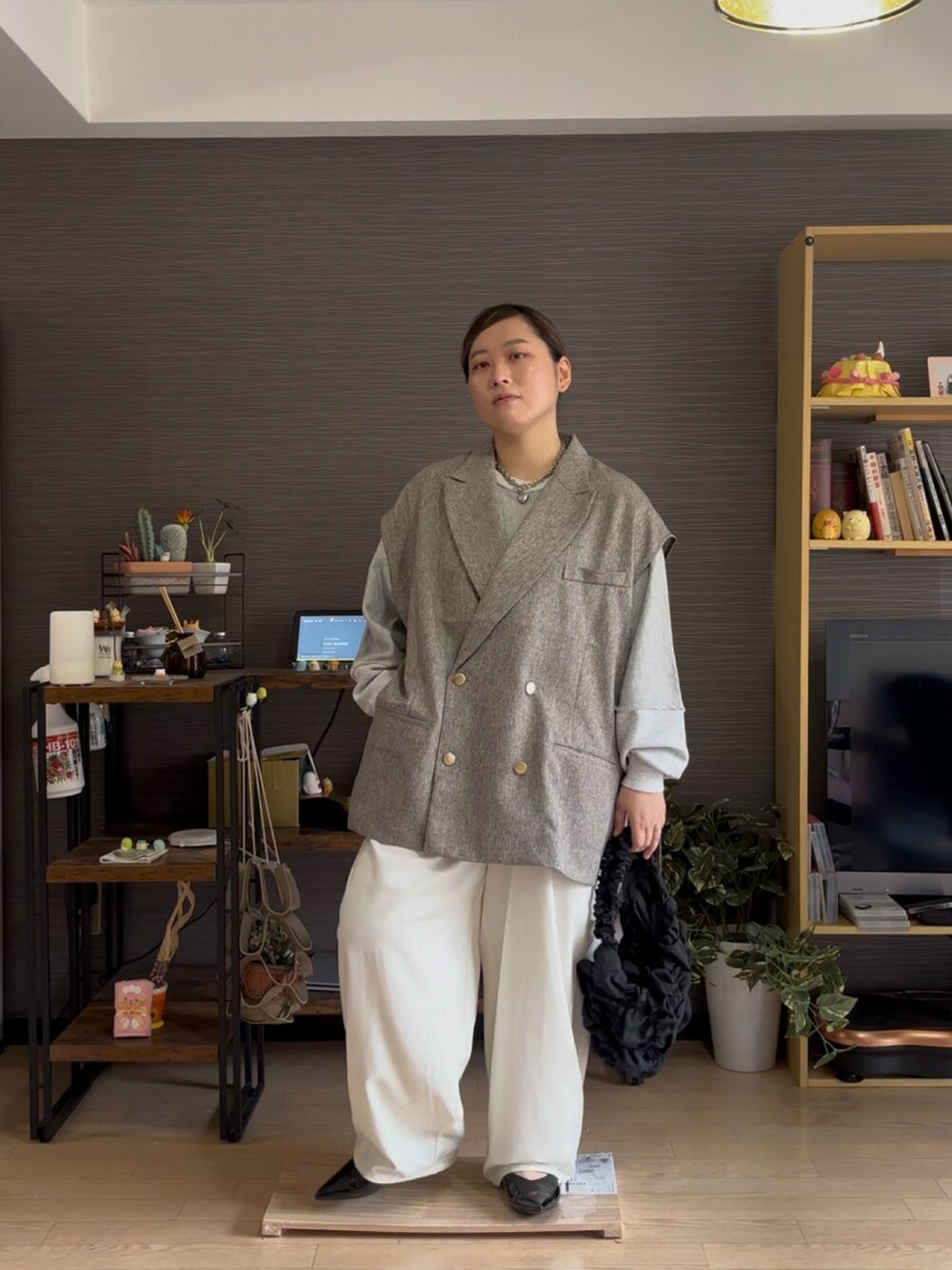 ベージュ系のベスト、ホワイト系のその他パンツ、ブラック系のパンプスを着用したレディースの春コーディネートの2枚目の写真