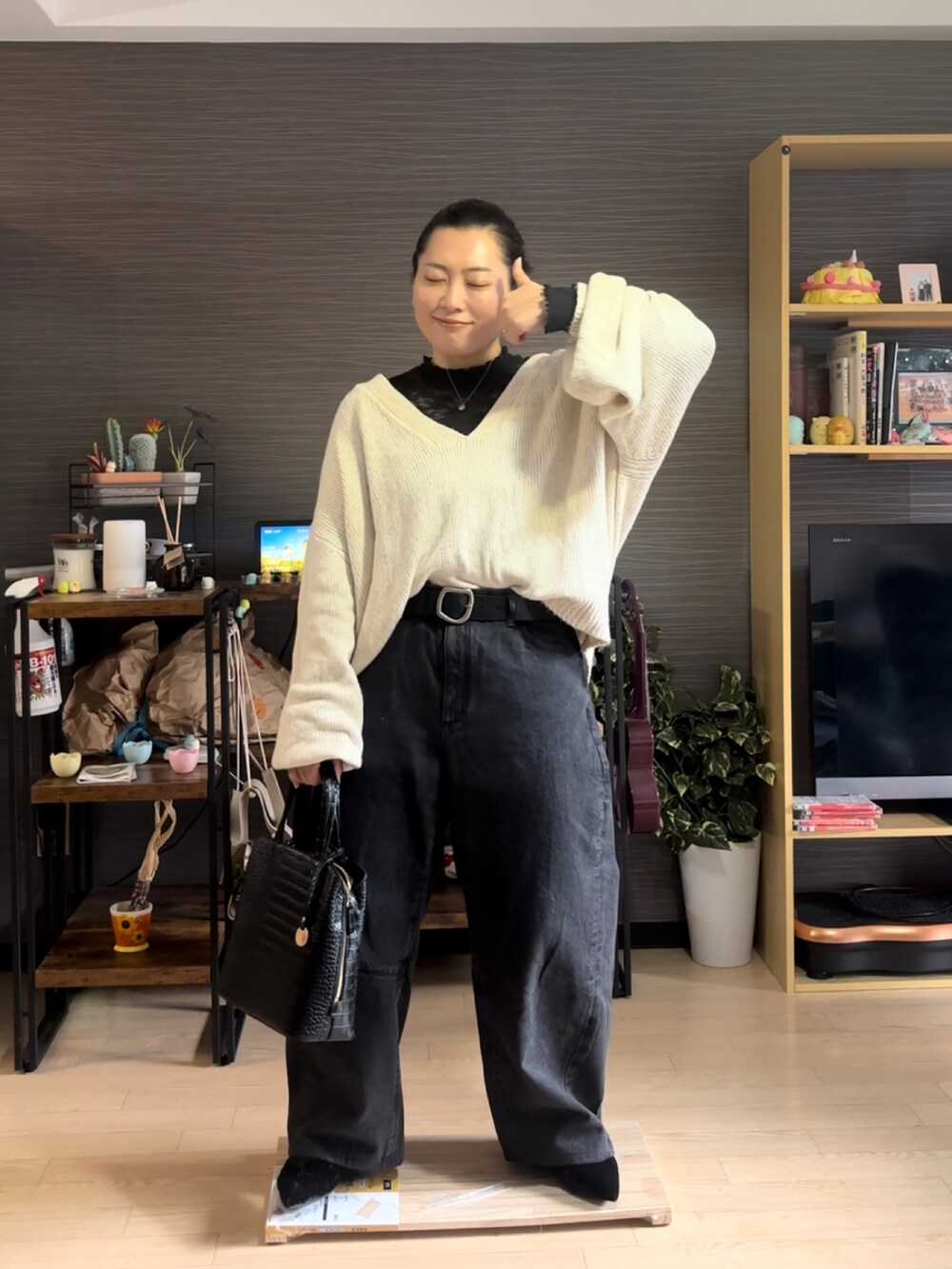ホワイト系のニット/セーター、ブラック系のデニムパンツ、ブラック系のパンプスを着用したレディースの冬コーディネートの3枚目の写真