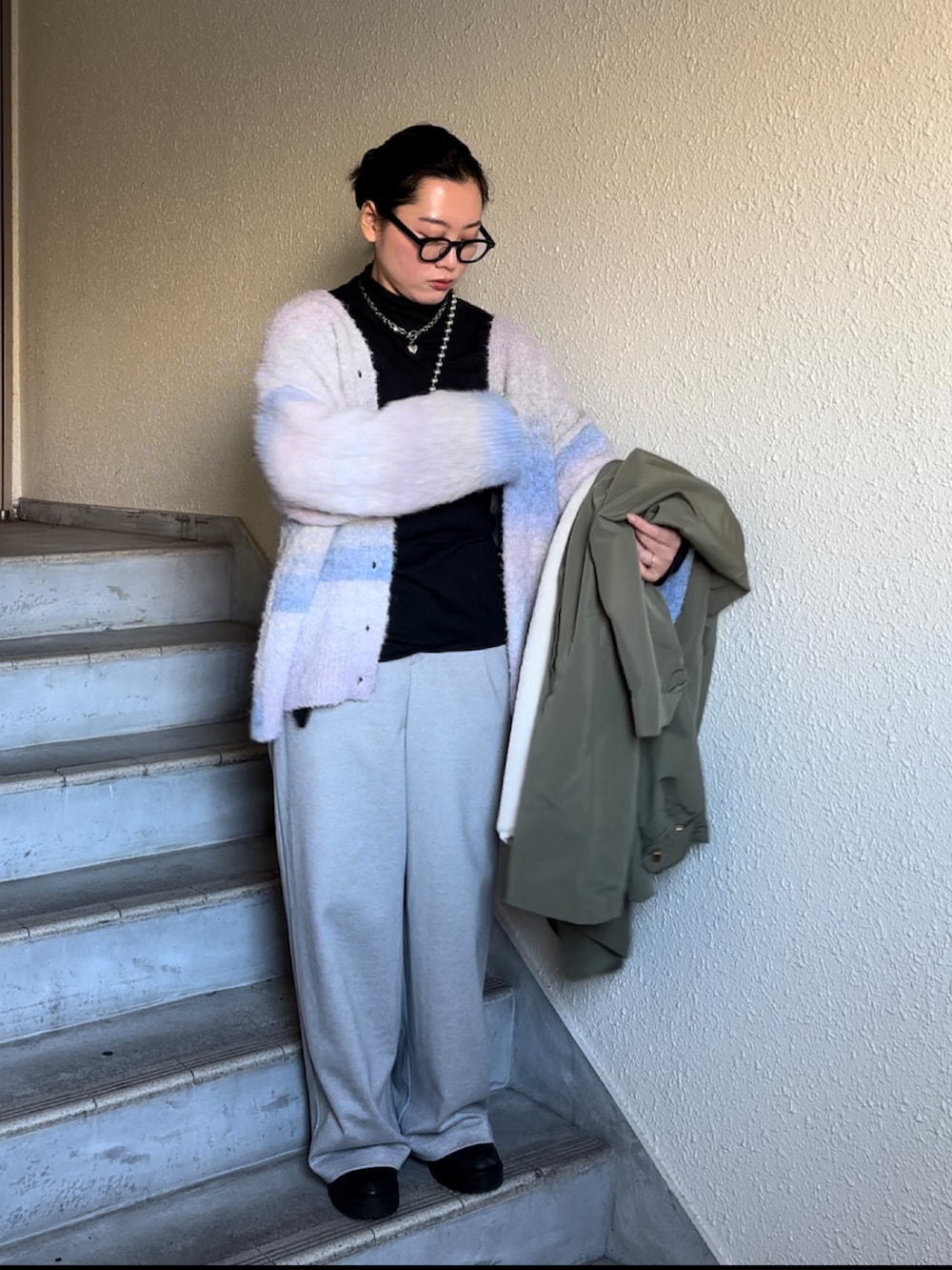 ブラック系のブーツ、グレー系のスウェットパンツ、ブラック系のTシャツ/カットソーを着用したレディースの冬コーディネートの2枚目の写真