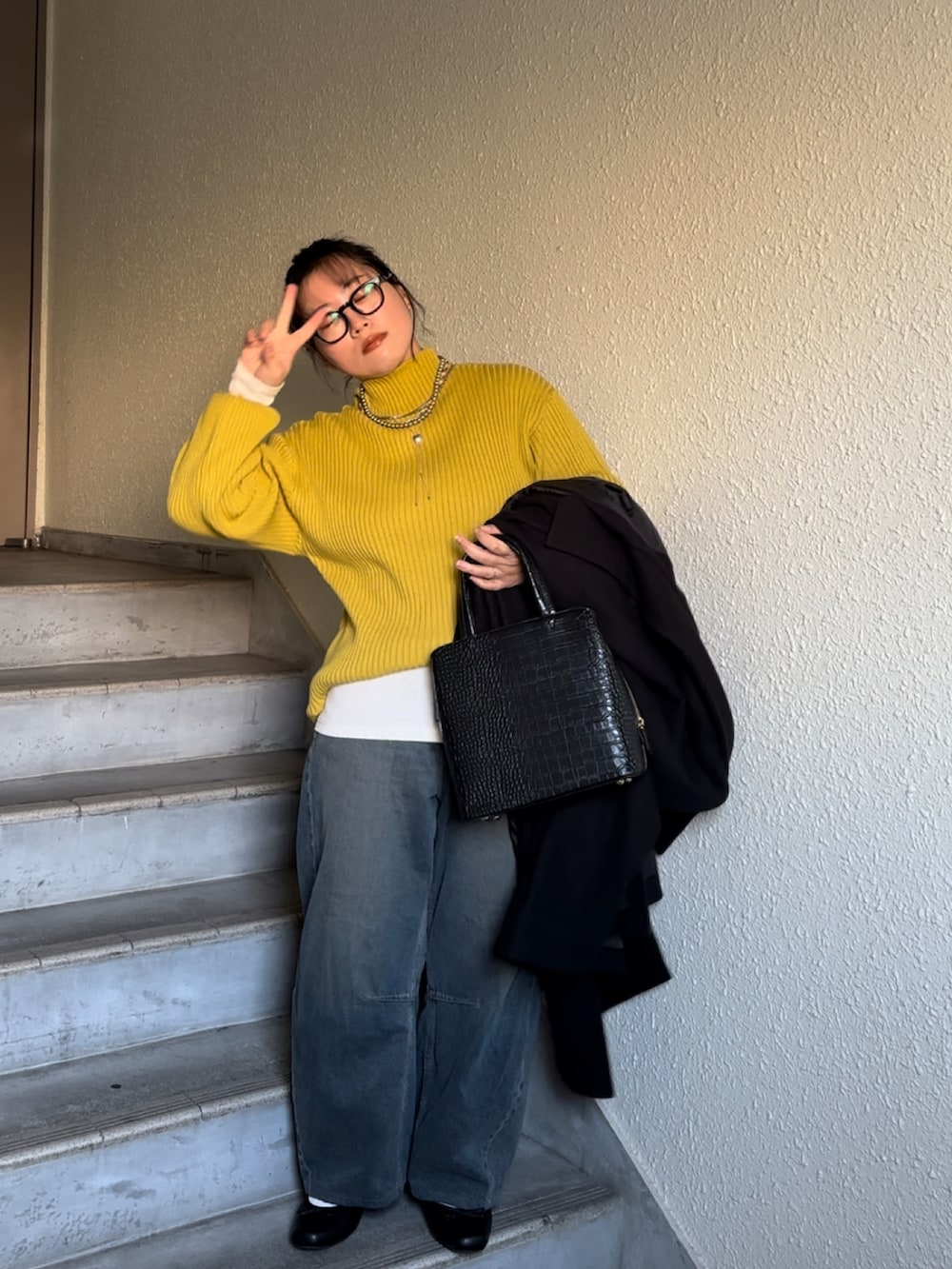 ブラック系のバレエシューズ、ブラック系のジャケット/アウター、イエロー系のニット/セーターを着用したレディースの冬コーディネートの2枚目の写真