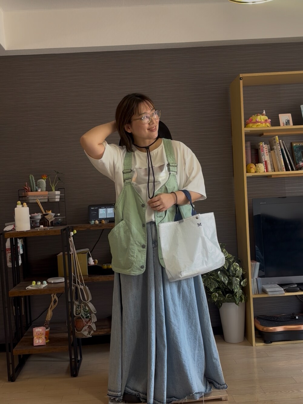 ブルー系のスカート、グリーン系のベスト、ホワイト系のTシャツ/カットソーを着用したレディースの夏コーディネートの2枚目の写真