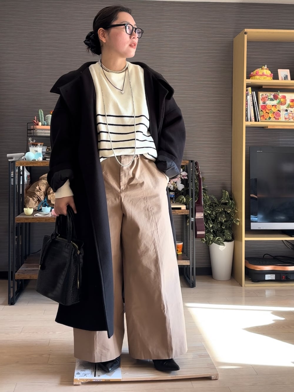 ブラック系のジャケット/アウター、ベージュ系のチノパンツ、ベージュ系のニット/セーターを着用したレディースの冬コーディネートの2枚目の写真