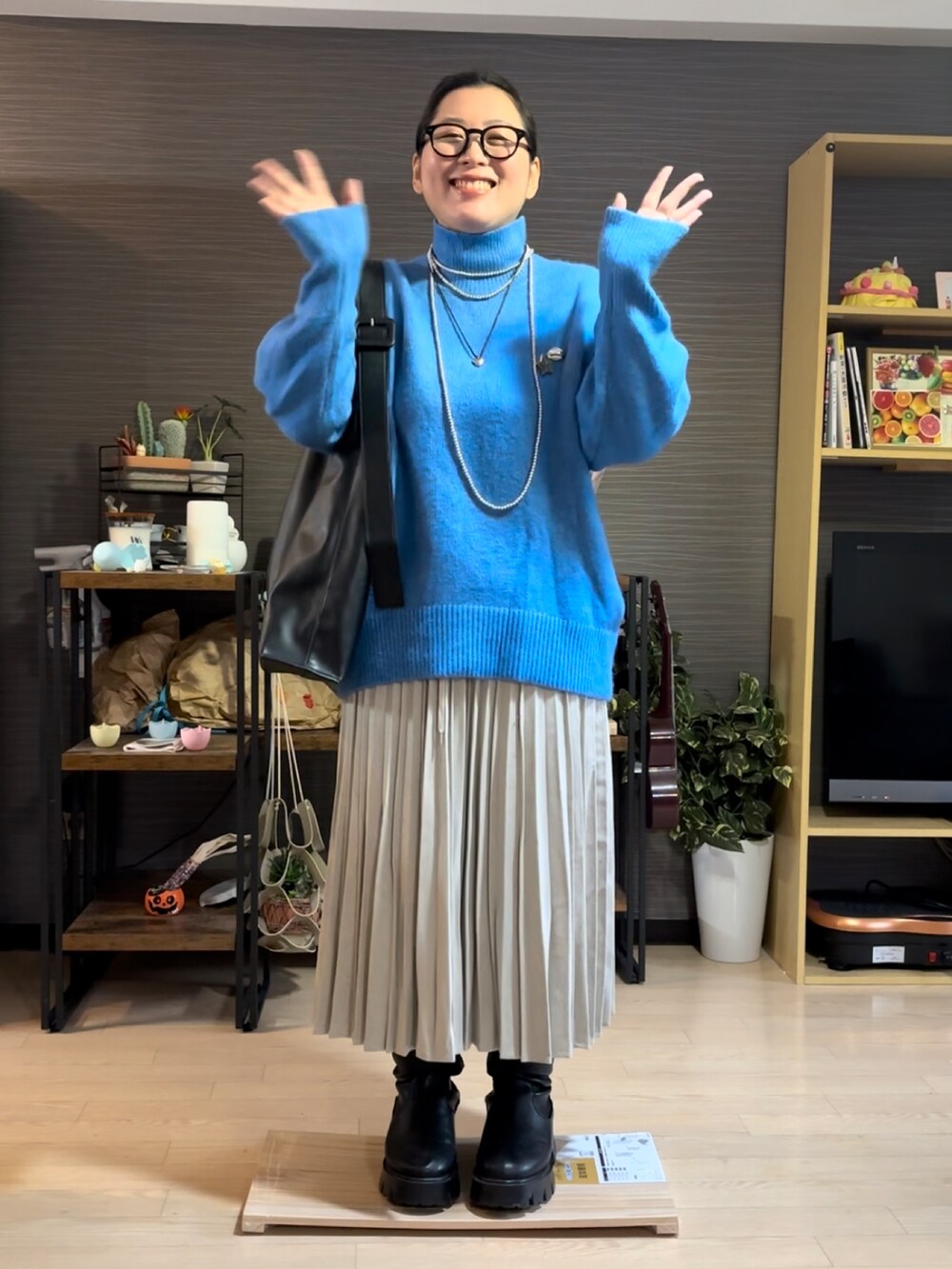 ベージュ系のスカート、ブラック系のブーツを着用したレディースの冬コーディネートの2枚目の写真