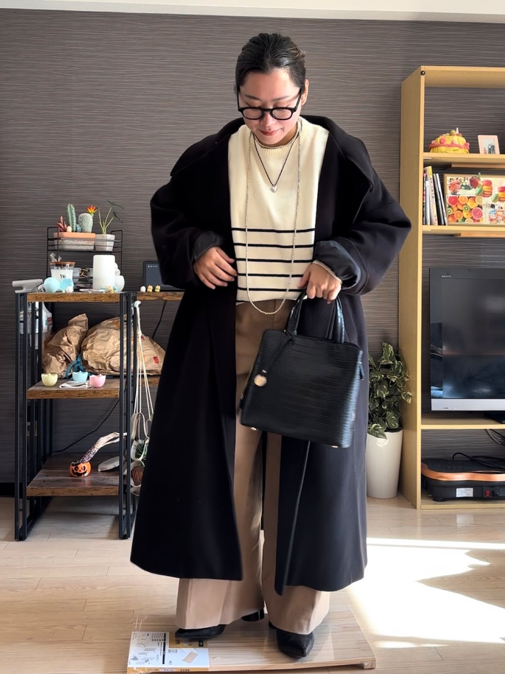 ブラック系のジャケット/アウター、ベージュ系のチノパンツ、ベージュ系のニット/セーターを着用したレディースの冬コーディネートの3枚目の写真