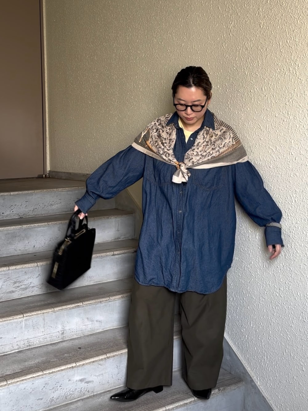 ブルー系のシャツ/ブラウス、ブラック系のバッグ、グリーン系のチノパンツを着用したレディースの春コーディネートの2枚目の写真