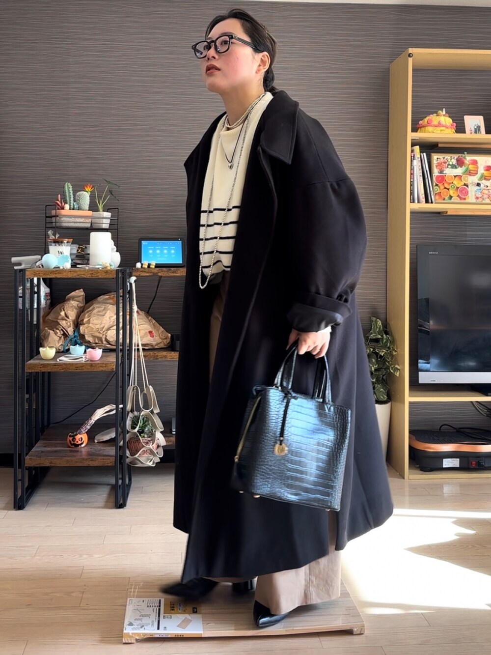 ブラック系のジャケット/アウター、ベージュ系のチノパンツ、ベージュ系のニット/セーターを着用したレディースの冬コーディネートの4枚目の写真