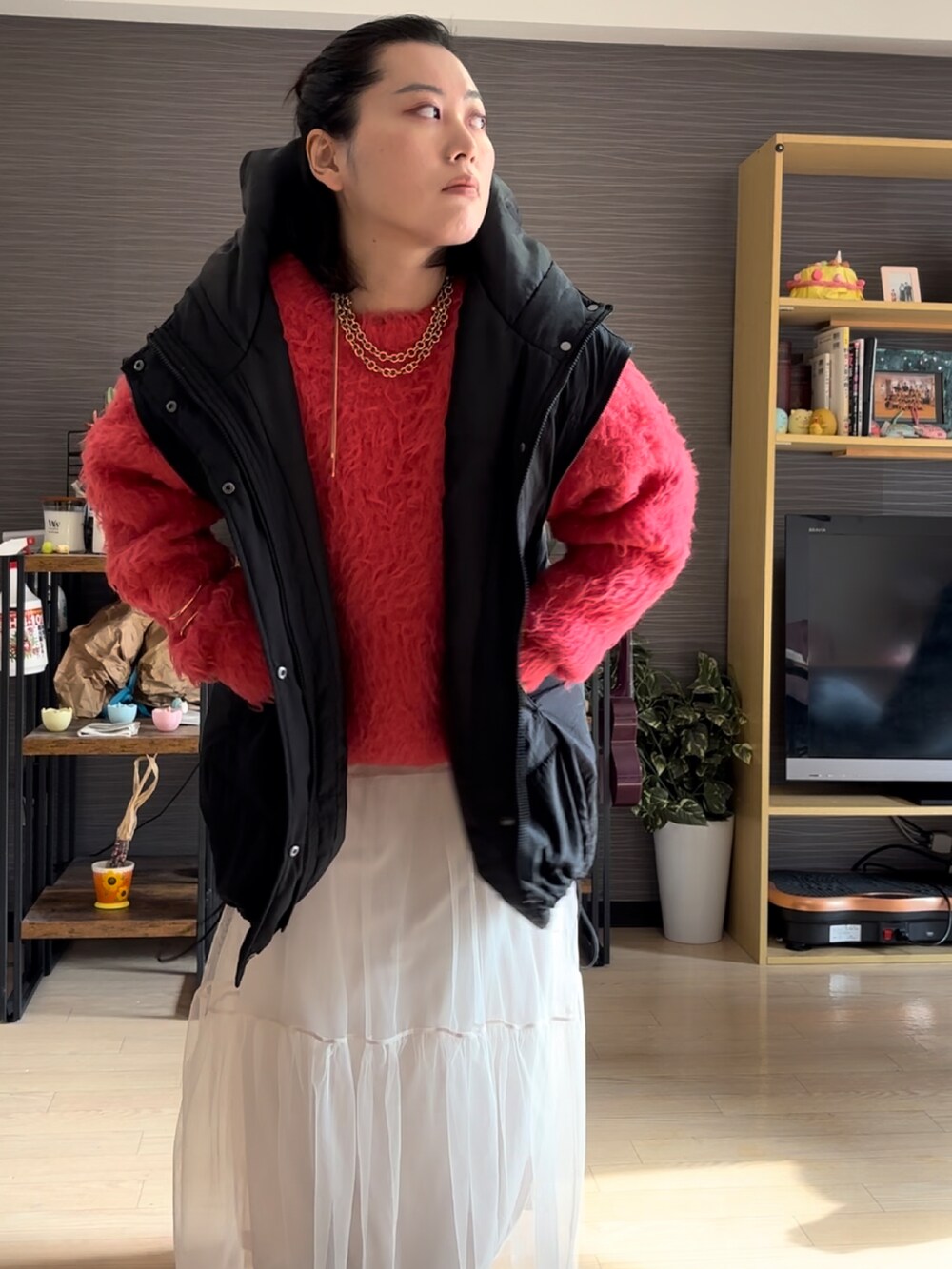 ピンク系のニット/セーター、ブラック系のブルゾン、ホワイト系のスカートを着用したレディースの冬コーディネートの2枚目の写真