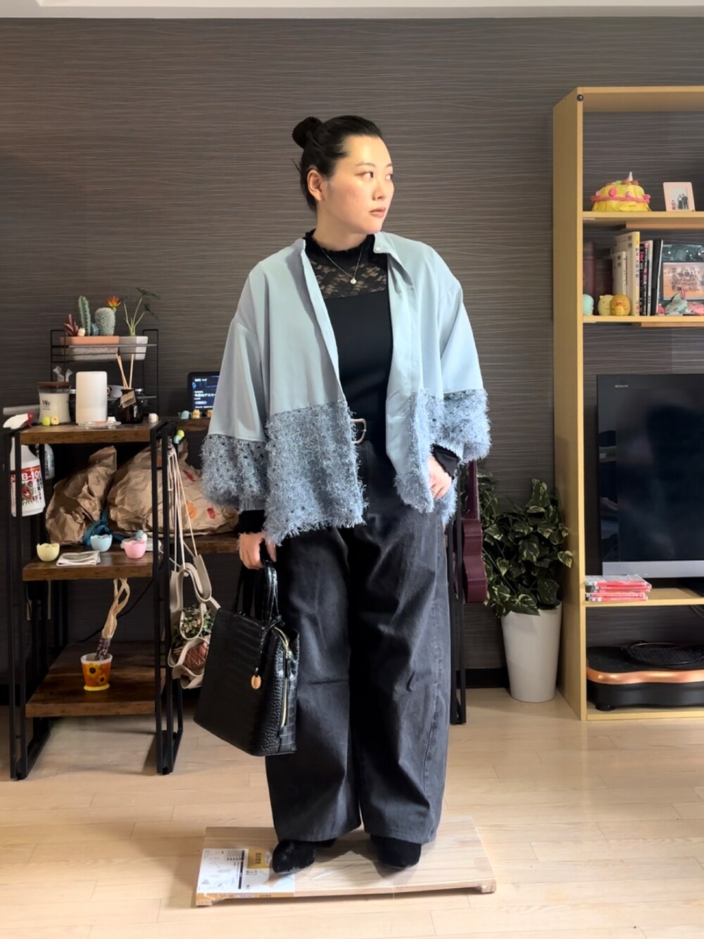ブルー系のシャツ/ブラウス、ブラック系のデニムパンツ、ブラック系のバッグを着用したレディースの冬コーディネートの2枚目の写真