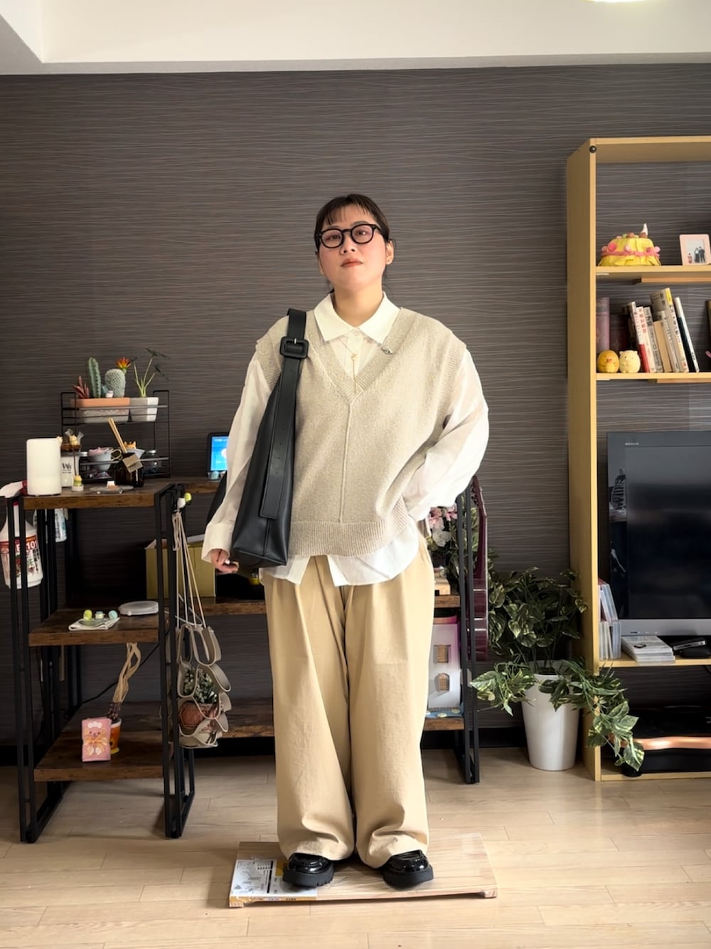 ベージュ系のチノパンツ、ベージュ系のベスト、ホワイト系のシャツ/ブラウスを着用したレディースの春コーディネートの2枚目の写真