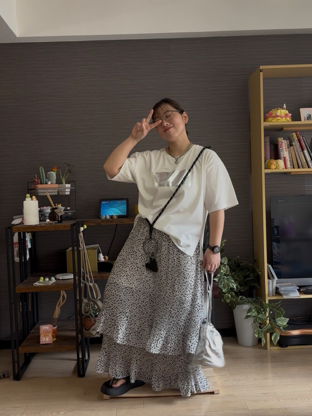 ホワイト系のスカート、ホワイト系のTシャツ/カットソー、ブラック系のサンダルを着用したレディースの夏コーディネートの2枚目の写真