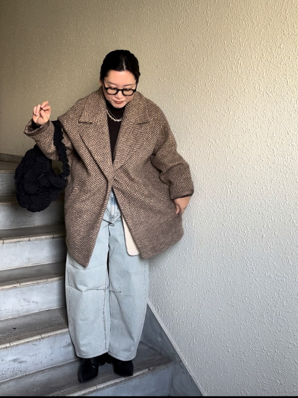 ブルー系のデニムパンツ、ブラック系のブーツ、ブラウン系のその他アウターを着用したレディースの冬コーディネートの3枚目の写真