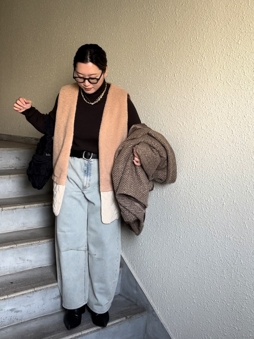 ブルー系のデニムパンツ、ブラック系のブーツ、ブラウン系のその他アウターを着用したレディースの冬コーディネートの2枚目の写真