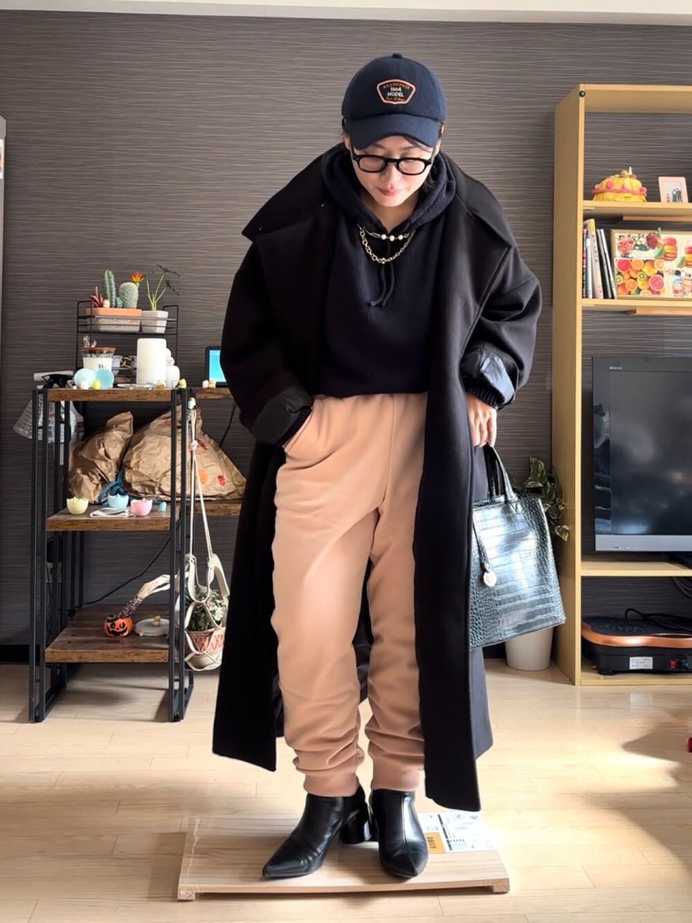 ブラック系のジャケット/アウター、ピンク系のスウェットパンツ、ブラック系のバッグを着用したレディースの冬コーディネートの2枚目の写真