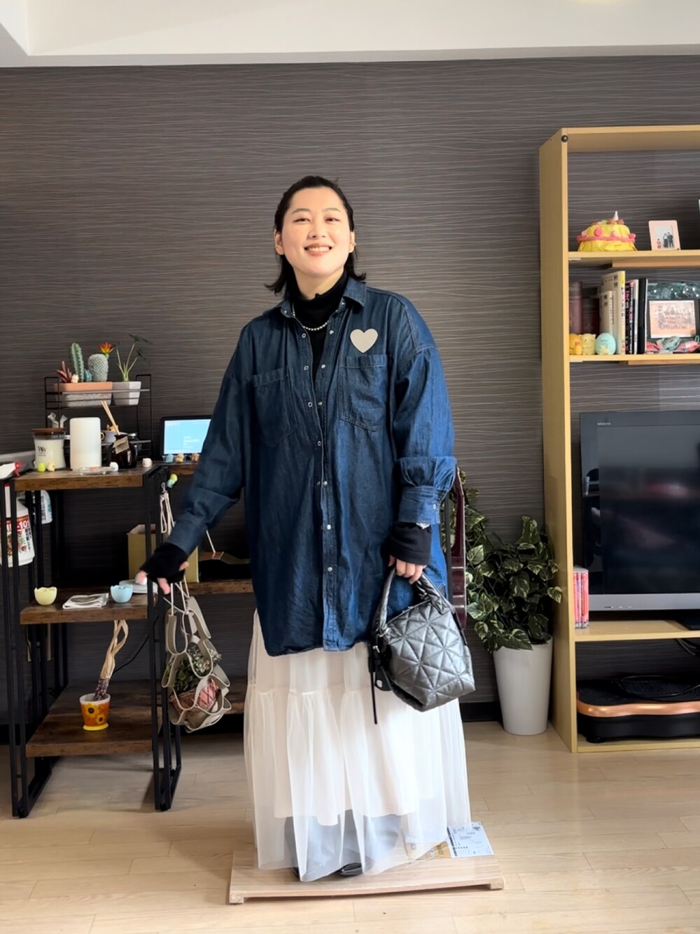 ブラック系のハンドバッグ、ブルー系のシャツ/ブラウス、ブラック系のTシャツ/カットソーを着用したレディースの春コーディネートの2枚目の写真