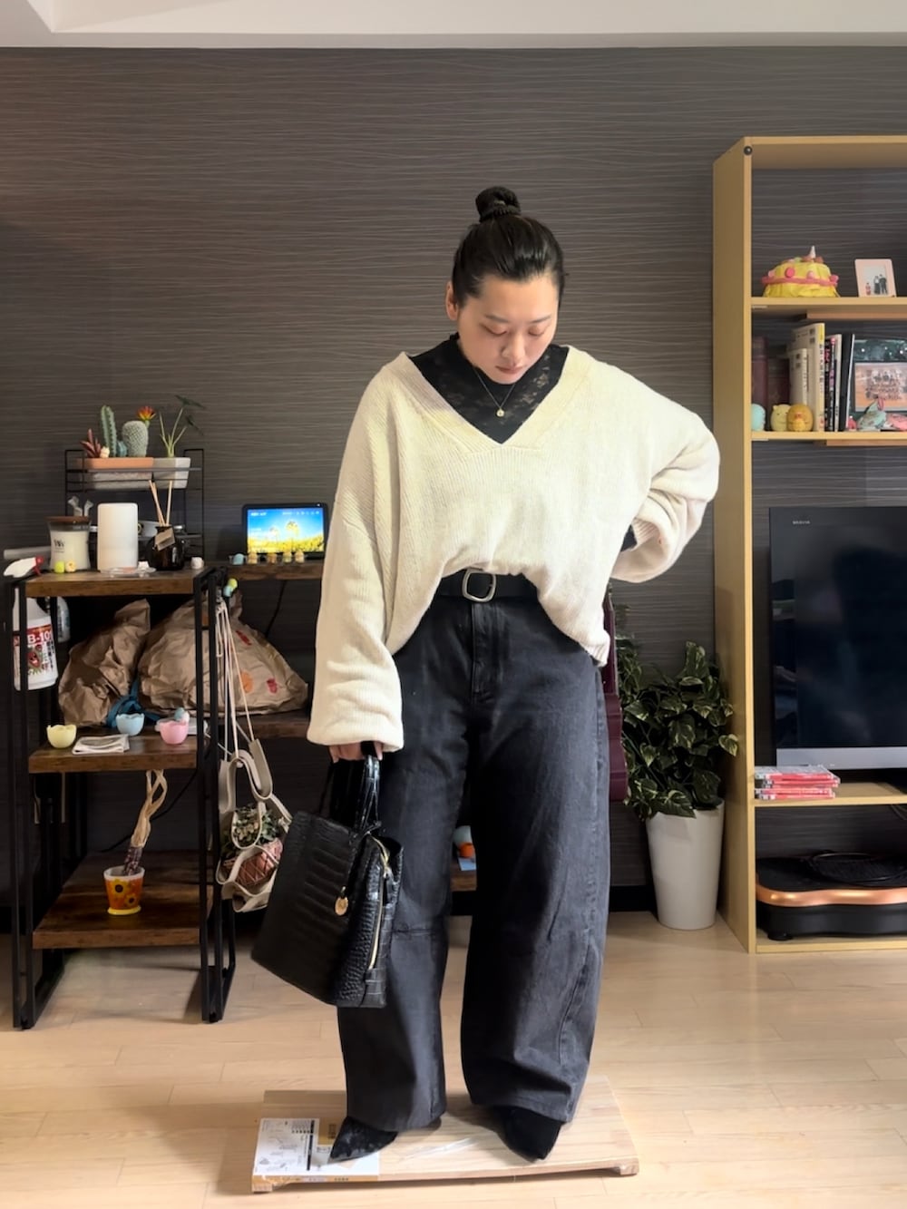 ホワイト系のニット/セーター、ブラック系のデニムパンツ、ブラック系のパンプスを着用したレディースの冬コーディネートの2枚目の写真